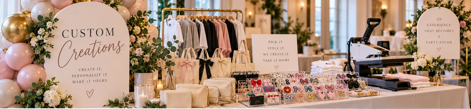Custom Creations mobile personalization bar concept styled with balloons, florals, bow totes, cosmetic bags, patch displays, an apparel rack and a heat press