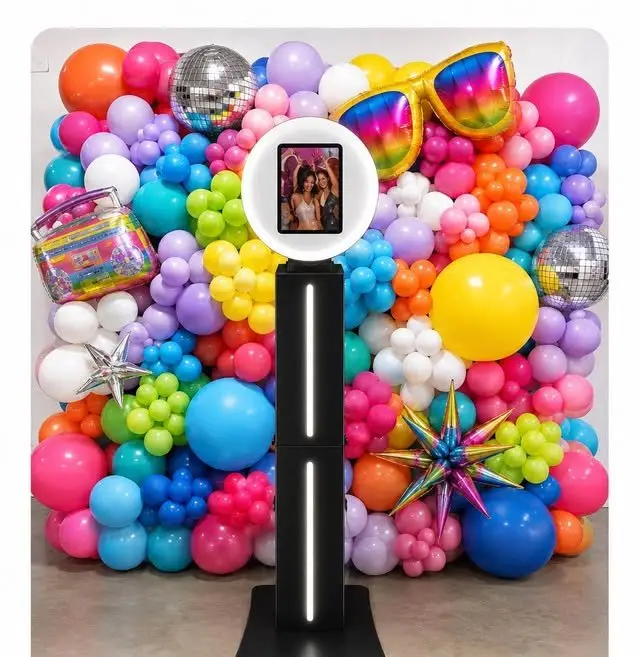 Photo booth in front of a deluxe balloon wall with disco balls and foil shapes