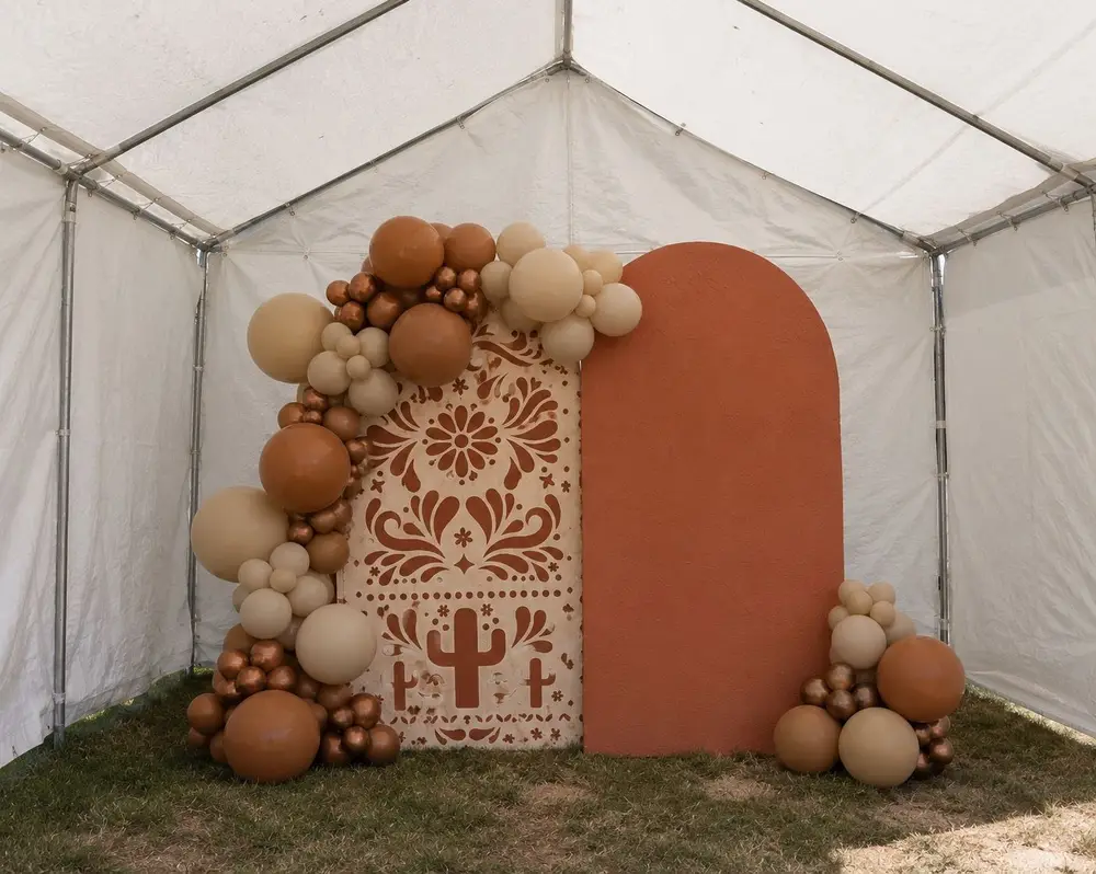 Terracotta arch backdrop with neutral balloons