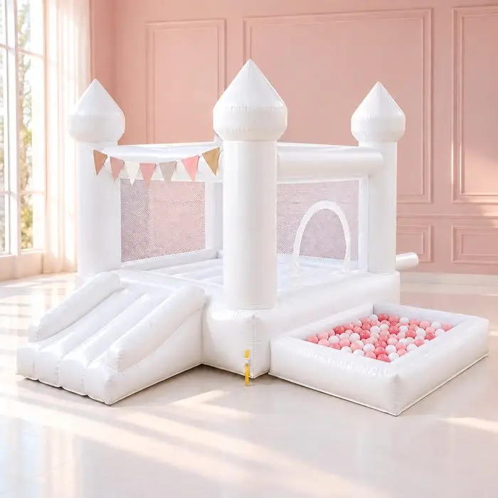 White bounce house castle with slide and a ball pit full of pink and white balls